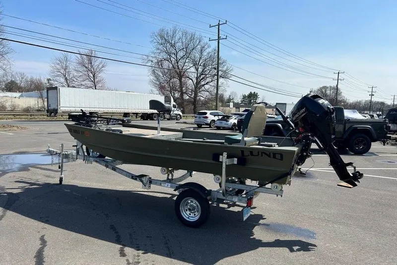 The Image of 2024 Lund UR1448MTD boat on trailer in parking lot, featuring outboard motor. - 1