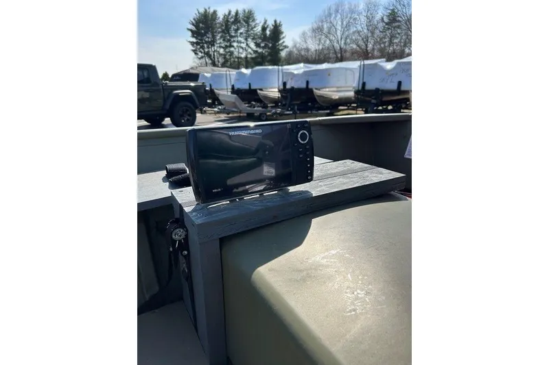 Slide: The Image of 2024 Lund UR1448MTD boat with Humminbird fish finder, parked outdoors. - 11