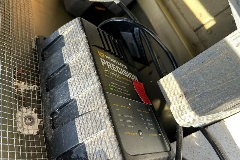 Slide: The Image of Minn Kota Precision charger in a 2024 Lund UR1448MTD boat, close-up view. - 12