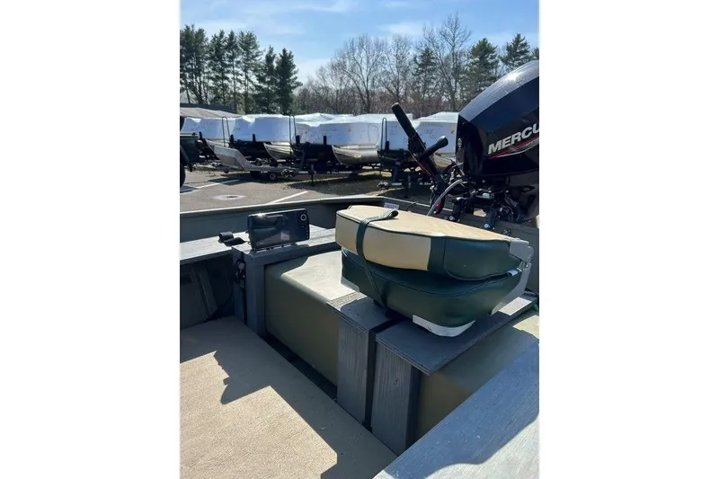 Slide: The Image of 2024 Lund UR1448MTD boat with Mercury motor, outdoor setting, surrounded by trees and other boats. - 15