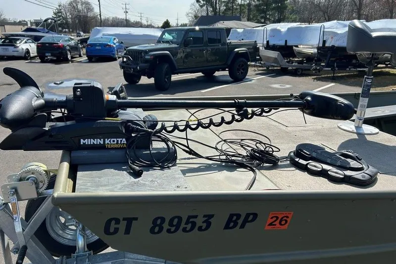 Slide: The Image of 2024 Lund UR1448MTD boat with Minn Kota Terrova motor in a parking lot. - 16