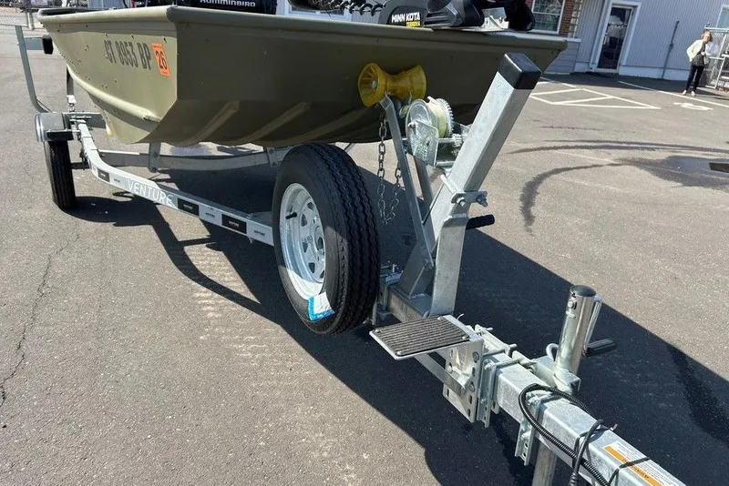 Slide: The Image of 2024 Lund UR1448MTD boat on trailer, parked in a lot. - 18