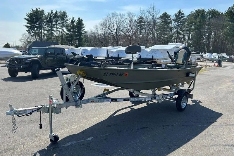 Slide: The Image of 2024 Lund UR1448MTD boat on trailer in parking lot, surrounded by trees and vehicles. - 5