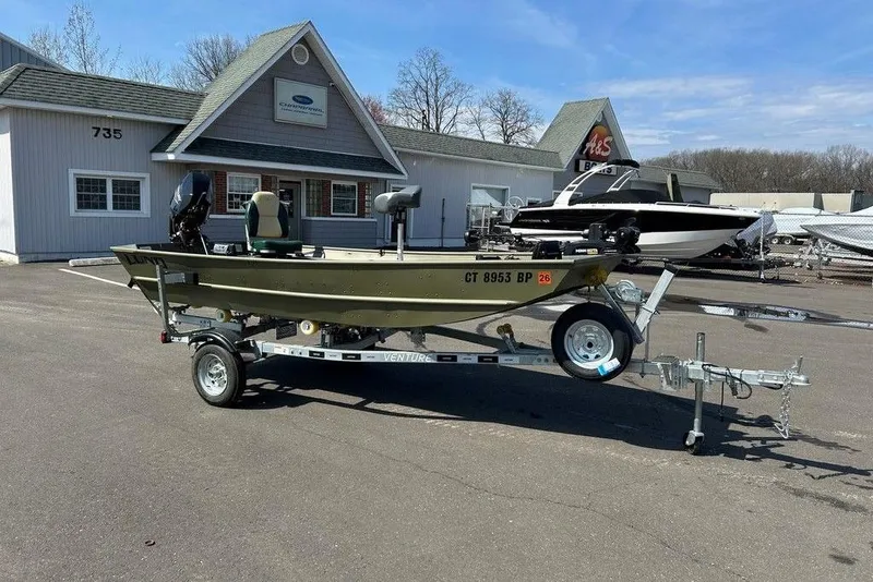 Slide: The Image of 2024 Lund UR1448MTD boat on trailer outside dealership. - 6