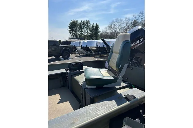 Slide: The Image of 2024 Lund UR1448MTD boat with seating and Mercury outboard motor in a parking lot. - 7