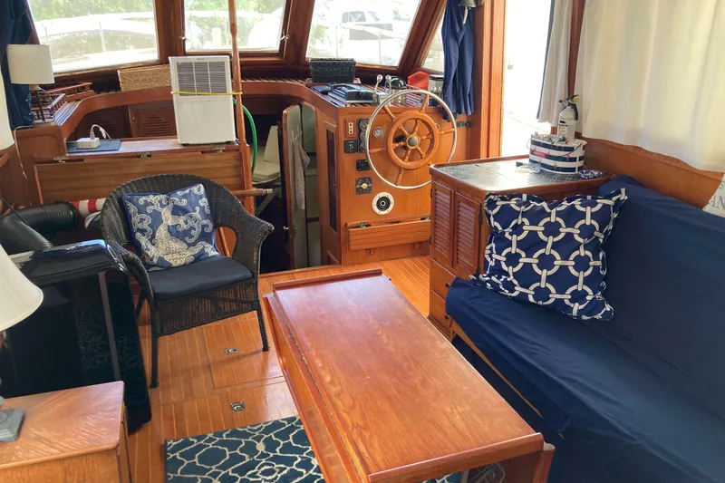 Slide: The Image of Interior of 1988 Albin 43 Trawler with wooden helm, seating, and nautical decor. - 16