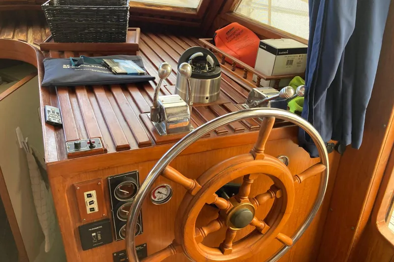 Slide: The Image of 1988 Albin 43 Trawler helm with wooden wheel, gauges, and navigation equipment. - 20
