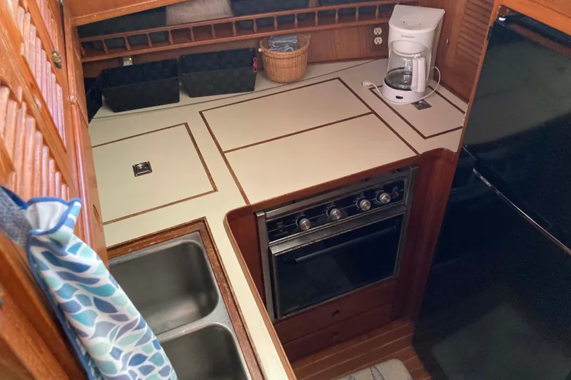 Slide: The Image of Compact kitchen area in a 1988 Albin 43 Trawler with stove and coffee maker. - 24