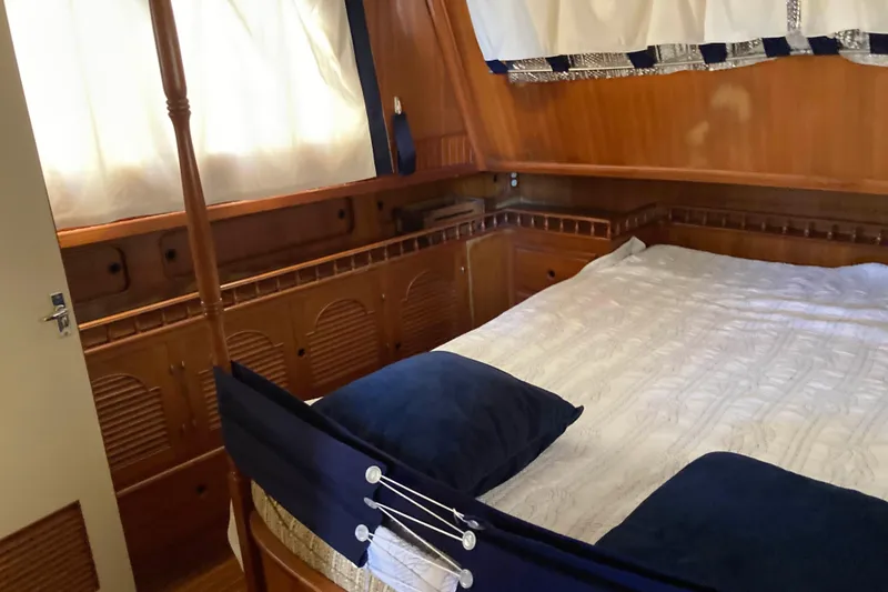 Slide: The Image of Cozy cabin interior of 1988 Albin 43 Trawler with wooden paneling and comfortable bedding. - 27