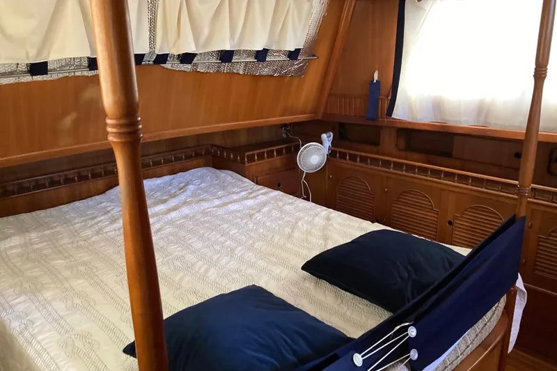 Slide: The Image of Cozy cabin interior of 1988 Albin 43 Trawler with wooden accents and comfortable bedding. - 28