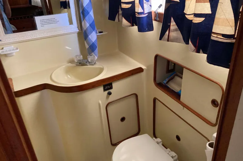 Slide: The Image of Bathroom interior of 1988 Albin 43 Trawler with nautical-themed curtains and compact design. - 32