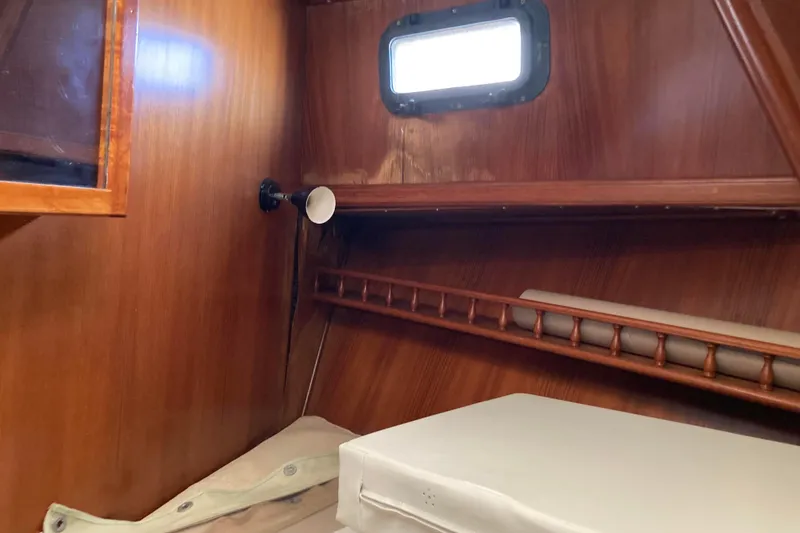 Slide: The Image of Interior cabin of 1988 Albin 43 Trawler with wooden paneling and small window. - 34