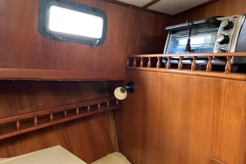 Slide: The Image of Interior of 1988 Albin 43 Trawler with wooden paneling and a small toaster oven. - 35