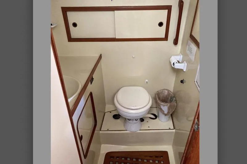 Slide: The Image of Compact bathroom in 1988 Albin 43 Trawler with toilet, sink, and wooden accents. - 38