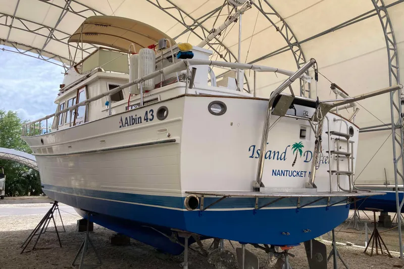 Slide: The Image of 1988 Albin 43 Trawler in dry dock, featuring white hull and blue accents. - 4