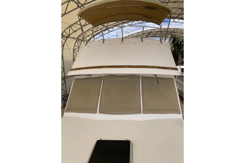 Slide: The Image of 1988 Albin 43 Trawler with covered windows and canopy, docked under shelter. - 7