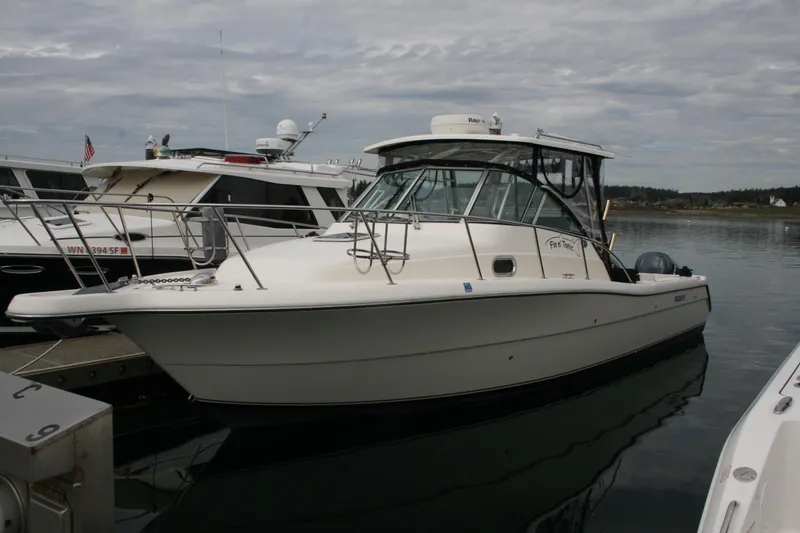 The Image of 2005 Pursuit 3070 Offshore boat docked in a marina, overcast sky. - 0