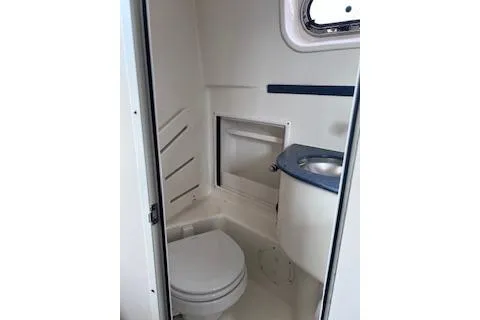 Slide: The Image of 2005 Pursuit 3070 Offshore boat bathroom with toilet and sink. - 10