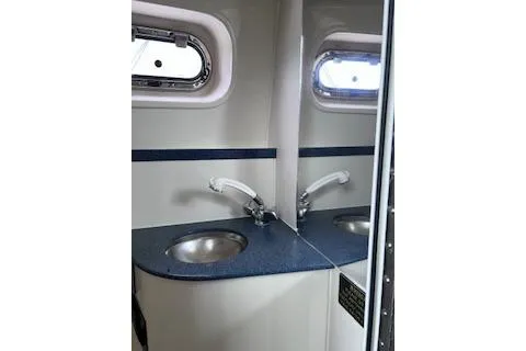 Slide: The Image of 2005 Pursuit 3070 Offshore boat bathroom with sink and mirror. - 11
