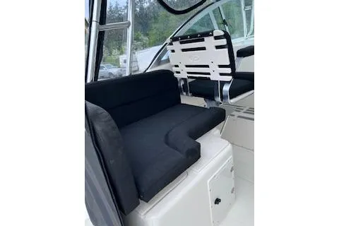 Slide: The Image of 2005 Pursuit 3070 Offshore boat interior with black seating and helm chair. - 12