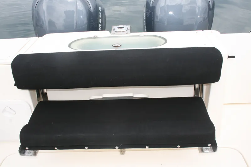 Slide: The Image of 2005 Pursuit 3070 Offshore boat with black cushioned seating and dual outboard motors. - 18