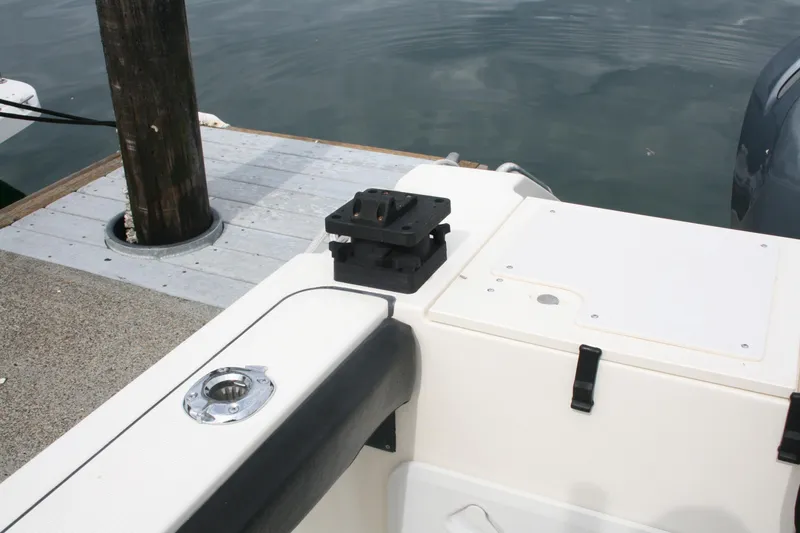 Slide: The Image of 2005 Pursuit 3070 Offshore boat docked, featuring deck details and water reflection. - 21