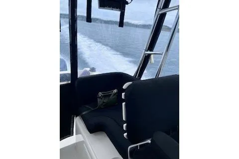 Slide: The Image of 2005 Pursuit 3070 Offshore boat interior with black seating, cruising on open water. - 3