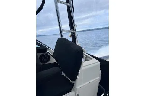 Slide: The Image of 2005 Pursuit 3070 Offshore boat interior with black seating, navigating calm waters. - 4