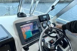 Slide: The Image of 2005 Pursuit 3070 Offshore boat dashboard with navigation equipment and steering wheel. - 5