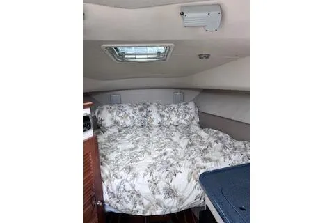 Slide: The Image of 2005 Pursuit 3070 Offshore cabin interior with floral bedding and overhead hatch. - 6
