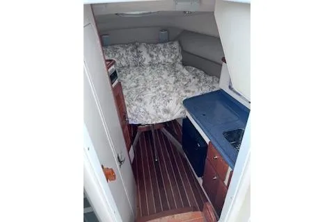 Slide: The Image of 2005 Pursuit 3070 Offshore cabin interior with bed and kitchenette. - 7