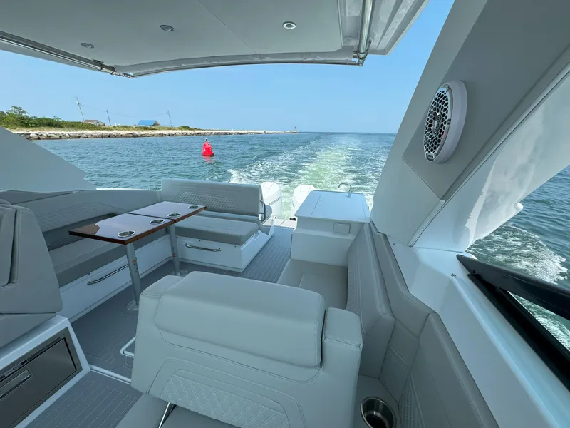 Slide: The Image of 2025 Cruisers Yachts 34 GLS Outboard interior, featuring luxurious seating and scenic water view. - 20