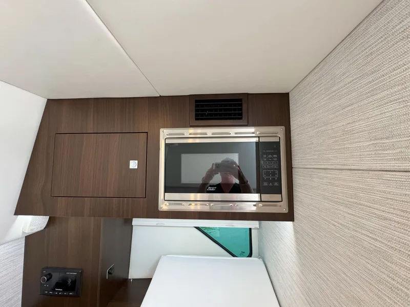 Slide: The Image of 2025 Cruisers Yachts 34 GLS Outboard interior with microwave and wood paneling. - 42