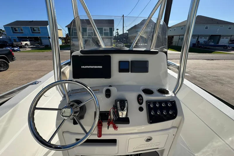 Slide: The Image of 2016 NauticStar 231 Coastal boat dashboard with steering wheel and controls. - 11