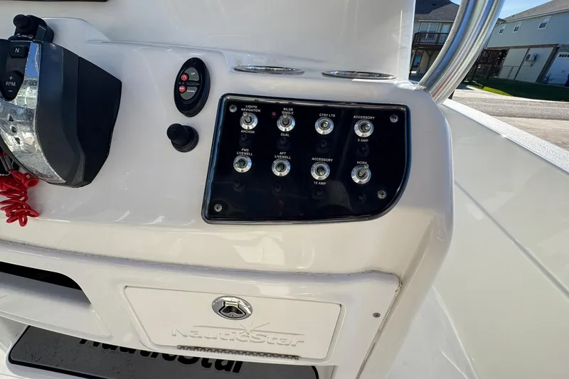 Slide: The Image of Control panel of a 2016 NauticStar 231 Coastal boat with switches and throttle. - 12