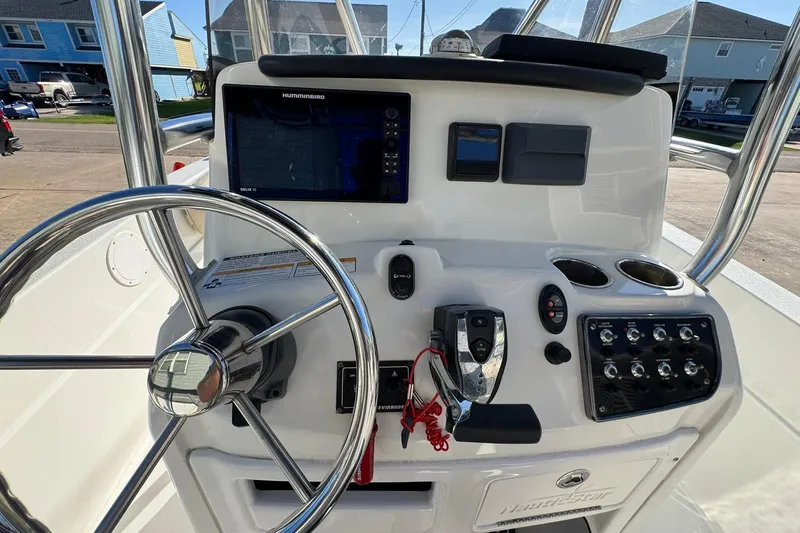 Slide: The Image of 2016 NauticStar 231 Coastal boat dashboard with steering wheel and control panel. - 14