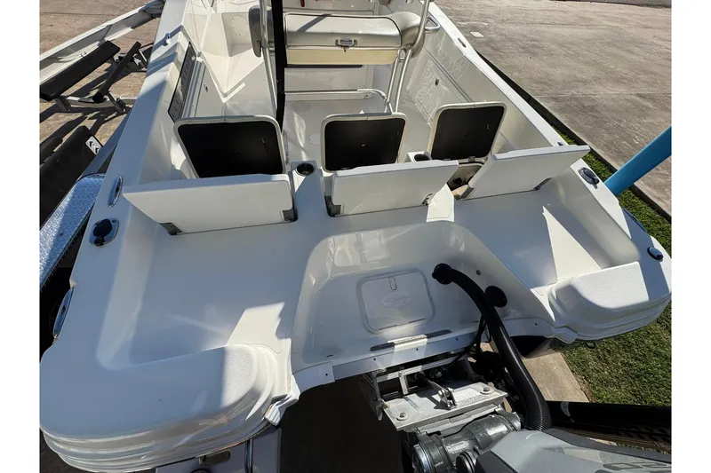 Slide: The Image of 2016 NauticStar 231 Coastal boat interior with open storage compartments and seating. - 16