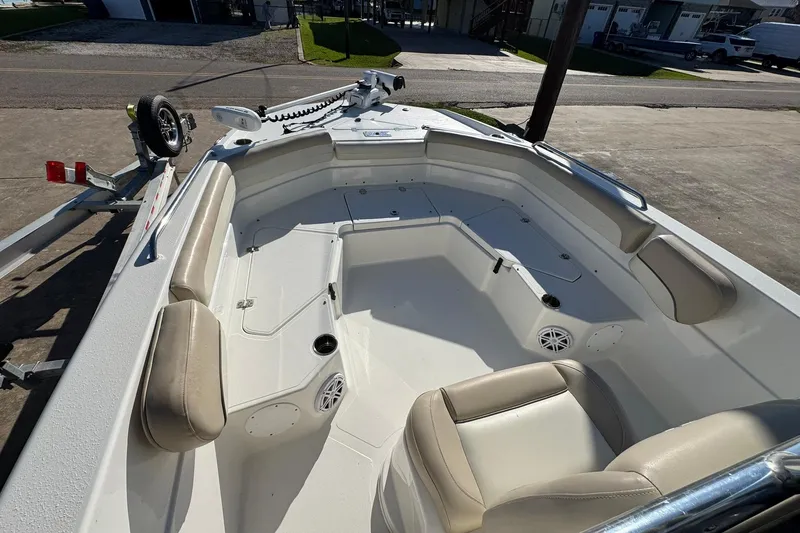 Slide: The Image of 2016 NauticStar 231 Coastal boat interior with beige seating and trailer. - 17