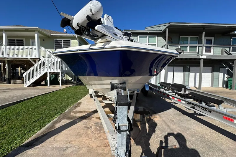 Slide: The Image of 2016 NauticStar 231 Coastal boat on trailer, parked in residential driveway. - 2