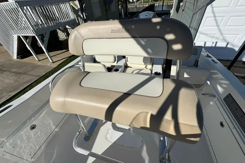 Slide: The Image of 2016 NauticStar 231 Coastal boat seat with beige upholstery and metal frame. - 21