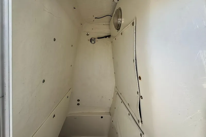 Slide: The Image of Interior cabin of 2016 NauticStar 231 Coastal boat, featuring white walls and storage compartments. - 27