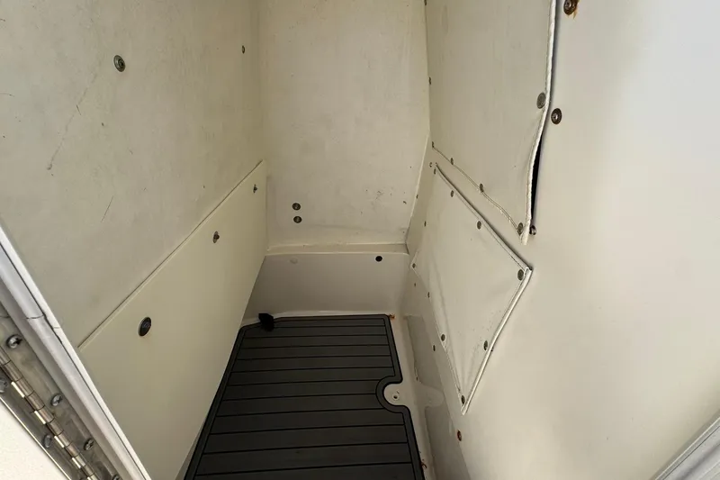 Slide: The Image of 2016 NauticStar 231 Coastal interior cabin with white walls and dark flooring. - 28