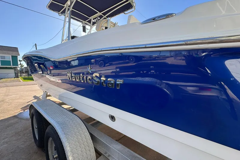 Slide: The Image of 2016 NauticStar 231 Coastal boat on trailer, blue and white exterior. - 4