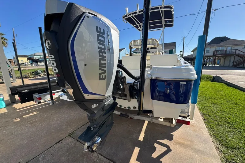 Slide: The Image of 2016 NauticStar 231 Coastal boat with Evinrude engine, parked on a driveway. - 5