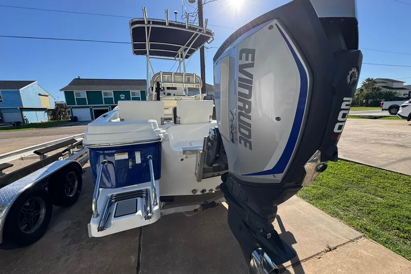 Slide: The Image of 2016 NauticStar 231 Coastal boat with Evinrude engine, parked on a driveway. - 6
