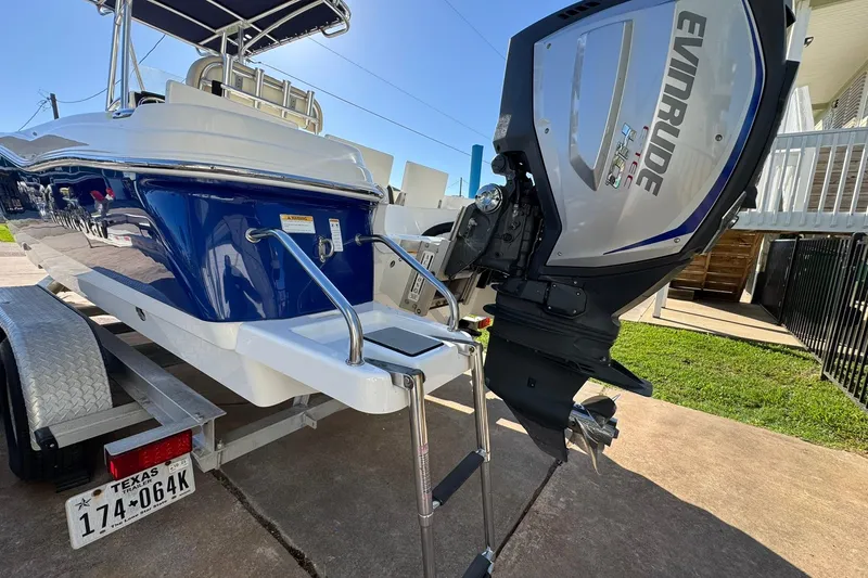 Slide: The Image of 2016 NauticStar 231 Coastal boat with Evinrude engine on trailer, Texas license plate visible. - 7