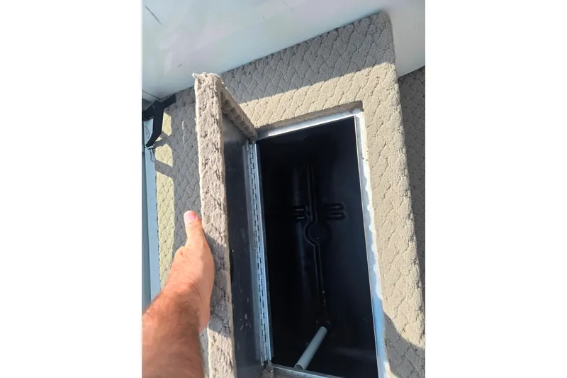 Slide: The Image of Hand opening storage compartment on 2006 Suncruiser Trinidad 220 boat. - 13