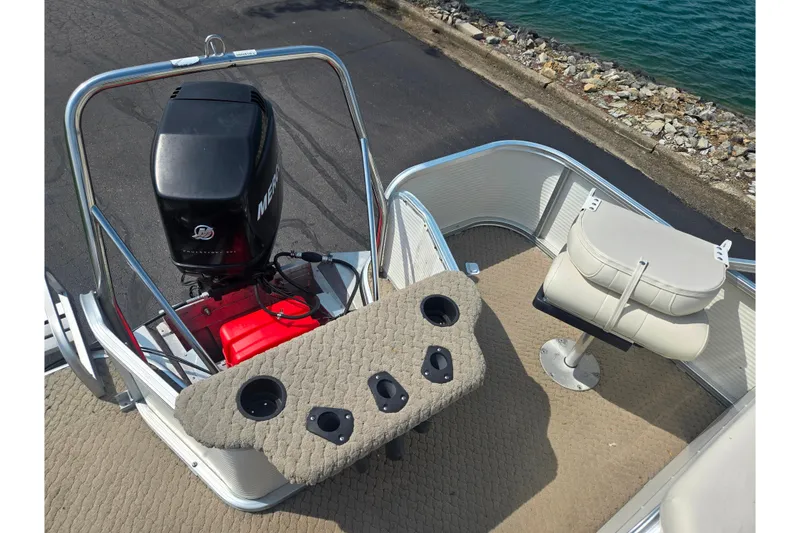 Slide: The Image of 2006 Suncruiser Trinidad 220 boat interior with motor and seating by the water. - 19