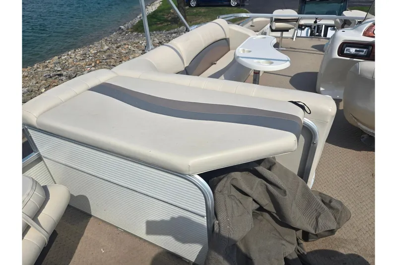 Slide: The Image of 2006 Suncruiser Trinidad 220 boat interior with beige seating and table by the water. - 20