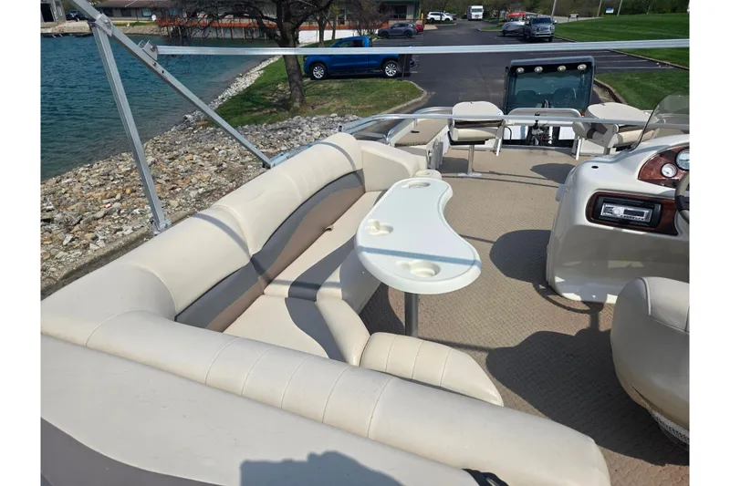 Slide: The Image of 2006 Suncruiser Trinidad 220 pontoon boat with beige seating and a small table. - 22